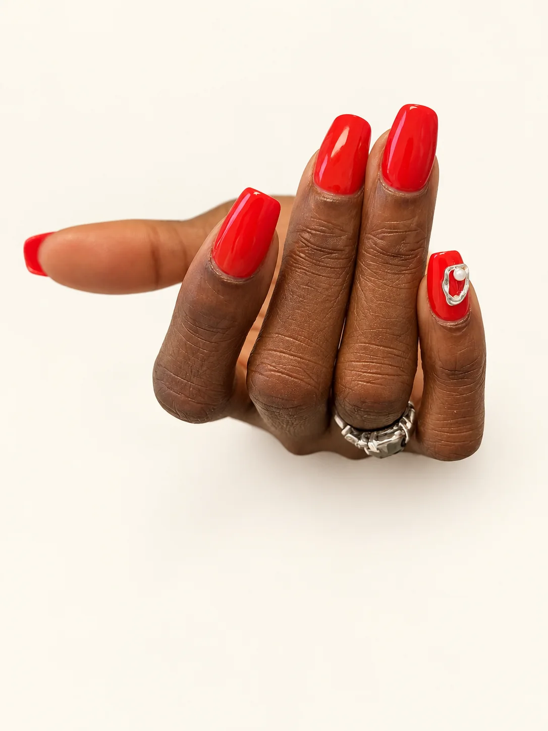 Nail art rouge et bijou d’ongle argenté sur l’auriculaire, réalisé à Bordeaux